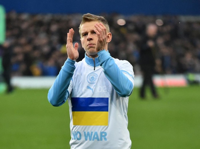 Soccer Football - Premier League - Everton v Manchester City - Goodison Park, Liverpool, Britain - February 26, 2022 Manchester City's Oleksandr Zinchenko wears a t-shirt which displays the Ukraine flag before the match REUTERS/Peter Powell EDITORIAL USE ONLY. No use with unauthorized audio, video, data, fixture lists, club/league logos or 'live' services. Online in-match use limited to 75 images, no video emulation. No use in betting, games or single club /league/player publications.  Please contact your account representative for further details.