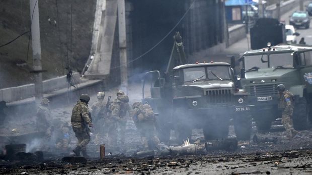 Ukrainian service members collect unexploded shells after a fighting with Russian raiding group in the Ukrainian capital of Kyiv in the morning of February 26, 2022, according to Ukrainian service personnel at the scene. - Ukrainian soldiers repulsed a Russian attack in the capital, the military said on February 26 after a defiant President Volodymyr Zelensky vowed his pro-Western country would not be bowed by Moscow. It started the third day since Russian leader Vladimir Putin unleashed a full-scale invasion that has killed dozens of people, forced more than 50,000 to flee Ukraine in just 48 hours and sparked fears of a wider conflict in Europe. (Photo by Sergei SUPINSKY / AFP)