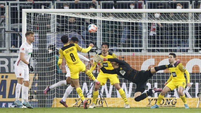 Augsburgs German midfielder Joel Noah Sarenren Bazee (Hidden, 3rdL) scores the equalising goal 1:1 during the German first division Bundesliga football match between FC Augsburg and Borussia Dortmund in Augsburg, southern Germany, on February 27, 2022. (Photo by MICHAELA REHLE / AFP) / DFL REGULATIONS PROHIBIT ANY USE OF PHOTOGRAPHS AS IMAGE SEQUENCES AND/OR QUASI-VIDEO