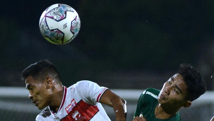Pesepak bola Madura United Asep Berlian (kiri) berebut bola dengan pesepak bola Persebaya Surabaya Marselino Ferdinan (kanan) dalam pertandingan Liga 1 di Stadion I Gusti Ngurah Rai, Denpasar, Bali, Senin (28/2/2022). ANTARA FOTO/Fikri Yusuf/tom.