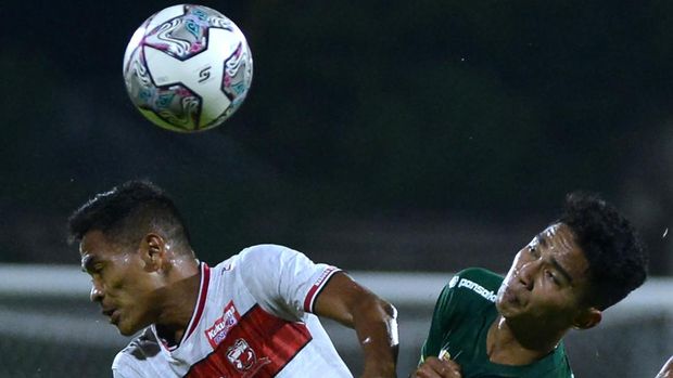 Pesepak bola Madura United Asep Berlian (kiri) berebut bola dengan pesepak bola Persebaya Surabaya Marselino Ferdinan (kanan) dalam pertandingan Liga 1 di Stadion I Gusti Ngurah Rai, Denpasar, Bali, Senin (28/2/2022). ANTARA FOTO/Fikri Yusuf/tom.
