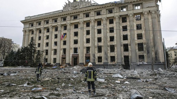 A member of the Ukrainian Emergency Service looks at the City Hall building in the central square following shelling in Kharkiv, Ukraine, Tuesday, March 1, 2022. (AP Photo/Pavel Dorogoy)