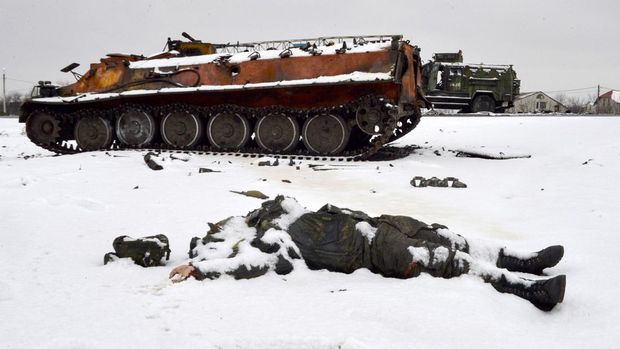 The body of a Russian serviceman lies near destroyed Russian military vehicles on the roadside on the outskirts of Kharkiv on February 26, 2022, following the Russian invasion of Ukraine. - Ukrainian forces repulsed a Russian attack on Kyiv but 
