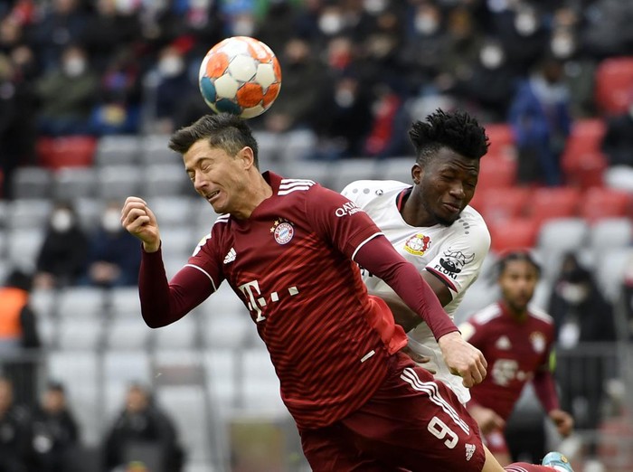Bayern's Robert Lewandowski, left, vies for the ball with Leverkusen's Edmond Tapsoba during the German Bundesliga soccer match between FC Bayern Munich and Bayer 04 Leverkusen at the Allianz Arena in Munich, Germany, Saturday, March 5, 2022. (AP Photo/Andreas Schaad)