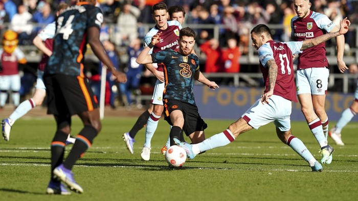 Chelseas Jorginho, center, and Burnleys Dwight McNeil, right, battle for the ball during the English Premier League soccer match between Burnley and Chelsea at Turf Moor, Burnley, England, Saturday, March 5, 2022. (Martin Rickett/PA via AP)