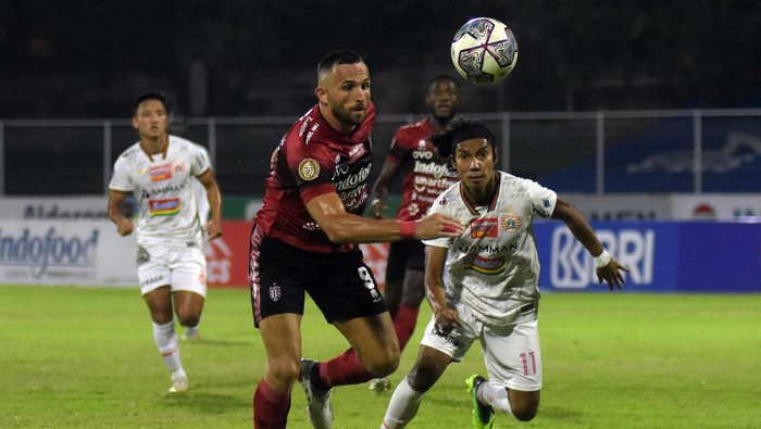 Pesepak bola Bali United Ilija Spasojevic (tengah) berusaha melewati hadangan pesepak bola Persija Jakarta Novri (kanan) pada pertandingan Liga 1 di Stadion I Gusti Ngurah Rai, Denpasar, Bali, Minggu (6/3/2022) malam. ANTARA FOTO/Nyoman Hendra Wibowo/nym.