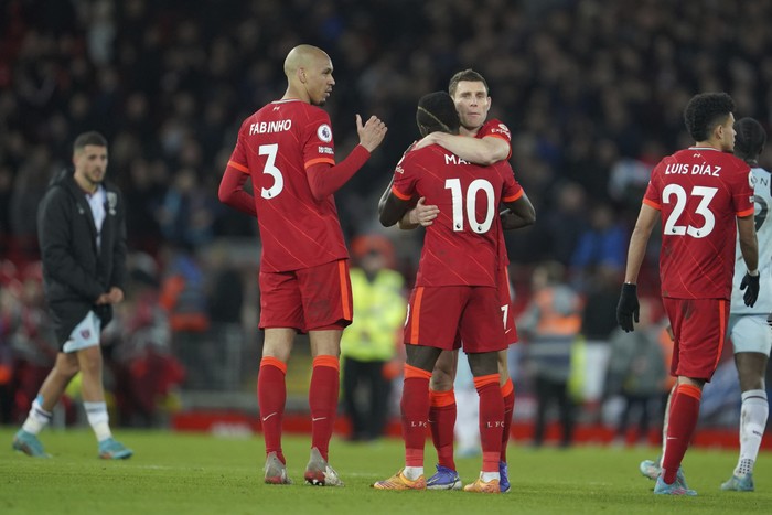 Liverpool's Sadio Mane, center back to camera, hugs a teammate to celebrate their win in the English Premier League soccer match against West Ham United at Anfield stadium in Liverpool, England, Saturday, March 5, 2022. (AP Photo/Jon Super)