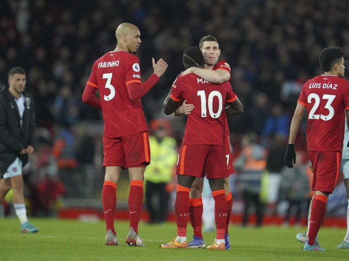 Liverpool's Sadio Mane, center back to camera, hugs a teammate to celebrate their win in the English Premier League soccer match against West Ham United at Anfield stadium in Liverpool, England, Saturday, March 5, 2022. (AP Photo/Jon Super)