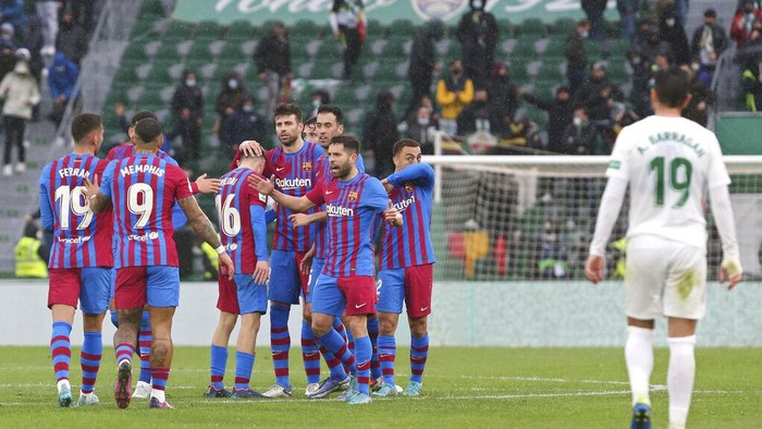 Barcelona players celebrate after defeating Elche at the end of a Spanish La Liga soccer match at the Martinez Valero stadium in Elche, Spain, Sunday, March 6, 2022. (AP Photo/Alberto Saiz)