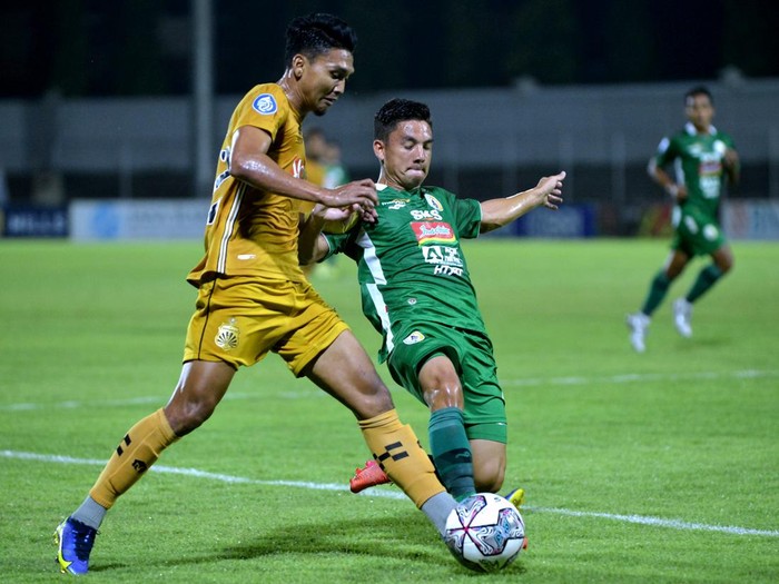 Pesepak bola Bhayangkara FC Dendy Sulistyawan (kiri) berebut bola dengan pesepak bola PSS Sleman Kim Kurniawan (kanan) saat pertandingan Liga 1 di Stadion Kompyang Sujana, Denpasar, Bali, Senin (7/3/2022). ANTARA FOTO/Fikri Yusuf/hp.