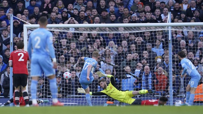 Manchester City's Kevin De Bruyne, center, scores his side's second goal during the English Premier League soccer match between Manchester City and Manchester United, at the Etihad stadium in Manchester, England, Sunday, March 6, 2022. (AP Photo/Jon Super)