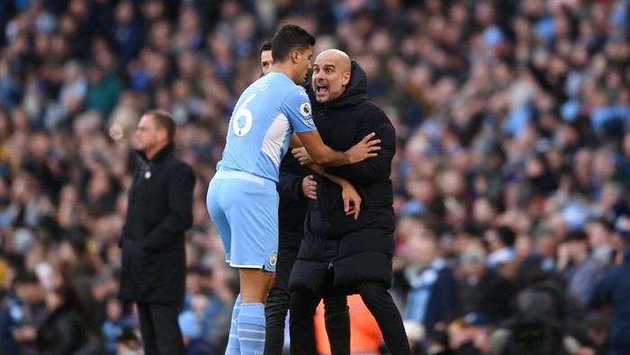 MANCHESTER, ENGLAND - MARCH 06: Rodrigo of Manchester City interacts with Pep Guardiola, Manager of Manchester City during the Premier League match between Manchester City and Manchester United at Etihad Stadium on March 06, 2022 in Manchester, England. (Photo by Laurence Griffiths/Getty Images)