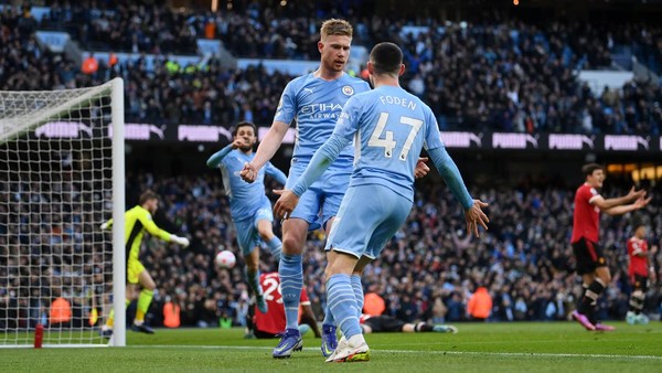 MANCHESTER, ENGLAND - MARCH 06: Kevin De Bruyne of Manchester City celebrates with team mate Phil Foden after scoring their sides second goal during the Premier League match between Manchester City and Manchester United at Etihad Stadium on March 06, 2022 in Manchester, England. (Photo by Michael Regan/Getty Images)