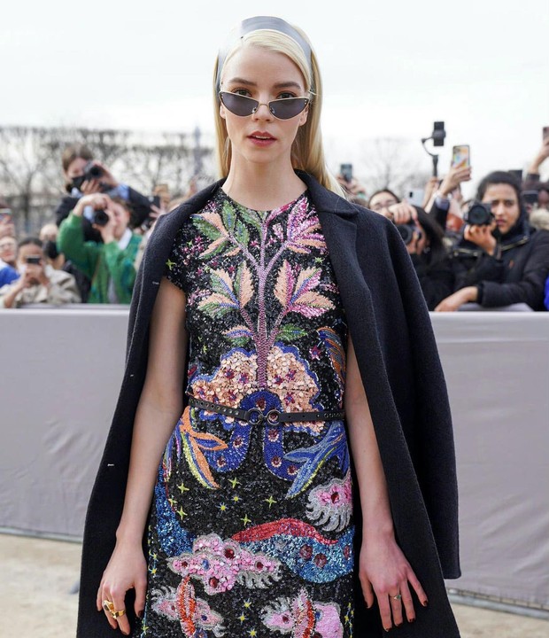 Anya Taylor-Joy memakai aksesori berupa angular glasses warna hitam serta ikat kepala hitam Anya Taylor-Joy