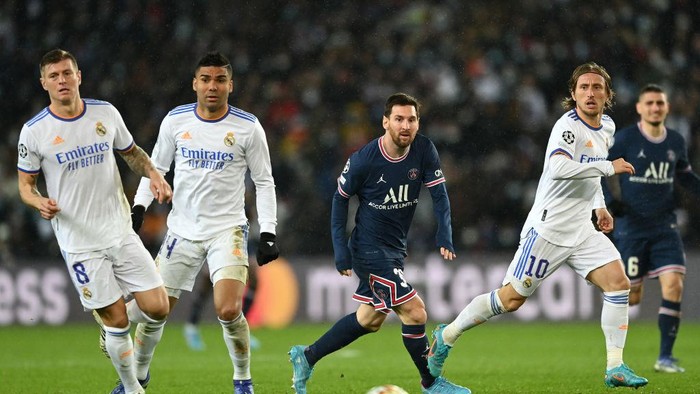Lionel Messi PARIS, FRANCE - FEBRUARY 15: Lionel Messi of Paris Saint-Germain runs with the ball from Toni Kroos, Casemiro and Luka Modric of Real Madrid during the UEFA Champions League Round Of Sixteen Leg One match between Paris Saint-Germain and Real Madrid at Parc des Princes on February 15, 2022 in Paris, France. (Photo by Shaun Botterill/Getty Images)