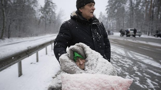 An elderly woman is coated in snow as she sits in a wheelchair after being evacuated from Irpin, on the outskirts of Kyiv, Ukraine, Tuesday, March 8, 2022. Demands for ways to safety evacuate civilians have surged along with intensifying shelling by Russian forces, who have made significant advances in southern Ukraine but stalled in some other regions. Efforts to put in place cease-fires along humanitarian corridors have repeatedly failed amid Russian shelling. (AP Photo/Vadim Ghirda)