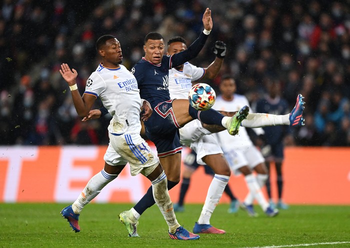 PARIS, FRANCE - FEBRUARY 15:  Kylian Mbappe of Paris Saint-Germain challenges David Alaba of Real Madrid during the UEFA Champions League Round Of Sixteen First Leg match between Paris Saint-Germain and Real Madrid at Parc des Princes on February 15, 2022 in Paris, France. (Photo by Shaun Botterill/Getty Images)