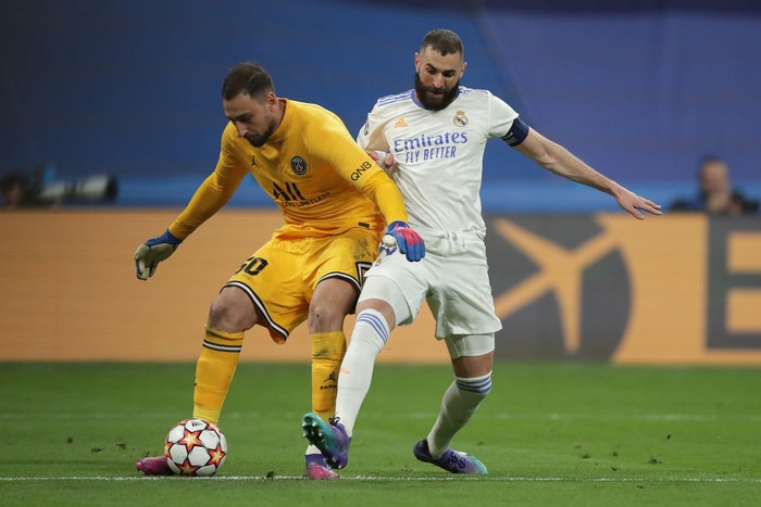 MADRID, SPAIN - MARCH 09: Karim Benzema (R) of Real Madrid CF competes for the ball with goalkeeper Gianluigi Donnarumma (L) of Paris Saint-Germain during the UEFA Champions League Round Of Sixteen Leg Two match between Real Madrid and Paris Saint-Germain at Estadio Santiago Bernabeu on March 09, 2022 in Madrid, Spain. (Photo by Gonzalo Arroyo Moreno/Getty Images)