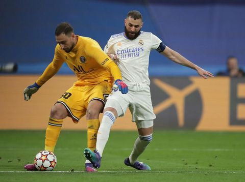 MADRID, SPAIN - MARCH 09: Karim Benzema (R) of Real Madrid CF competes for the ball with goalkeeper Gianluigi Donnarumma (L) of Paris Saint-Germain during the UEFA Champions League Round Of Sixteen Leg Two match between Real Madrid and Paris Saint-Germain at Estadio Santiago Bernabeu on March 09, 2022 in Madrid, Spain. (Photo by Gonzalo Arroyo Moreno/Getty Images)