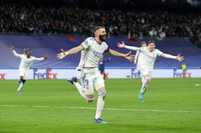 Karim Benzema MADRID, SPAIN - MARCH 09: Karim Benzema of Real Madrid CF celebrates scoring their second goal as Paris Saint-Germain players react during the UEFA Champions League Round Of Sixteen Leg Two match between Real Madrid and Paris Saint-Germain at Estadio Santiago Bernabeu on March 09, 2022 in Madrid, Spain. (Photo by Gonzalo Arroyo Moreno/Getty Images)