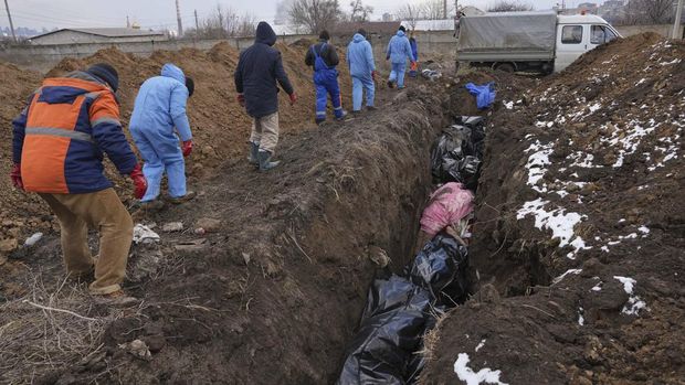 Dead bodies are put into a mass grave on the outskirts of Mariupol, Ukraine, Wednesday, March 9, 2022 as people cannot bury their dead because of the heavy shelling by Russian forces. (AP Photo/Evgeniy Maloletka)
