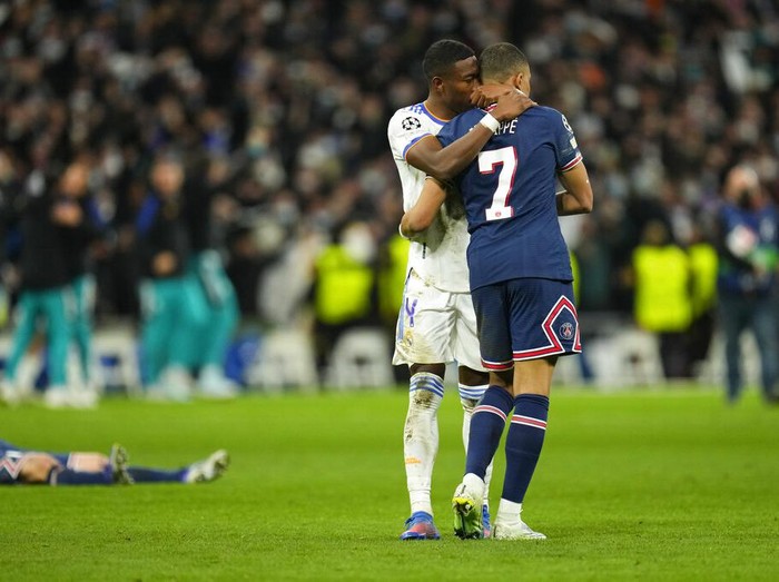 Real Madrid's David Alaba hugs PSG's Kylian Mbappe, right, after PSG's loss in the Champions League, round of 16, second leg soccer match between Real Madrid and Paris Saint-Germain at the Santiago Bernabeu stadium in Madrid, Spain, Wednesday, March 9, 2022. (AP Photo/Manu Fernandez)