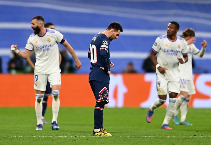 Lionel Messi MADRID, SPAIN - MARCH 09: Lionel Messi of Paris Saint-Germain (C) looks dejected after conceding their side's second goal while goal scorer Karim Benzema of Real Madrid (L) celebrates during the UEFA Champions League Round Of Sixteen Leg Two match between Real Madrid and Paris Saint-Germain at Estadio Santiago Bernabeu on March 09, 2022 in Madrid, Spain. (Photo by David Ramos/Getty Images)