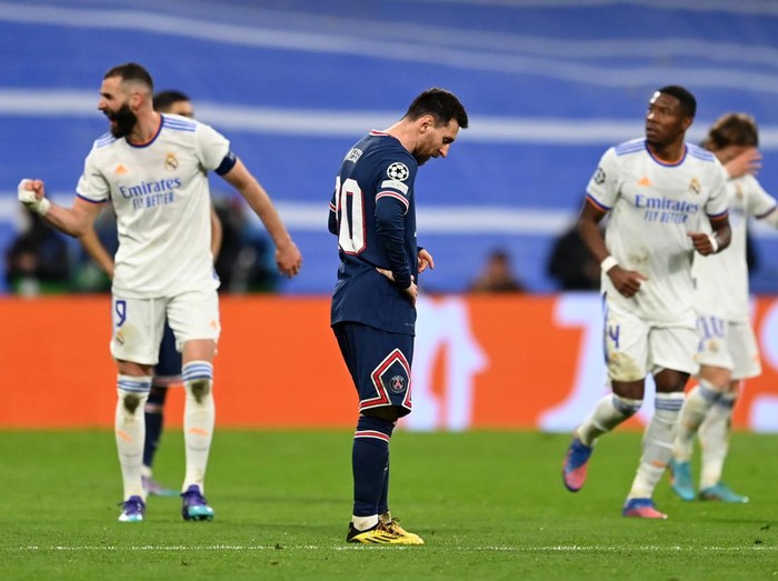 MADRID, SPAIN - MARCH 09: Lionel Messi of Paris Saint-Germain (C) looks dejected after conceding their side's second goal while goal scorer Karim Benzema of Real Madrid (L) celebrates during the UEFA Champions League Round Of Sixteen Leg Two match between Real Madrid and Paris Saint-Germain at Estadio Santiago Bernabeu on March 09, 2022 in Madrid, Spain. (Photo by David Ramos/Getty Images)