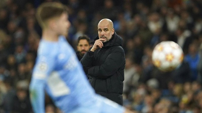 Manchester Citys head coach Pep Guardiola looks at the field during the Champions League round of 16 second leg soccer match between Manchester City and Sporting Lisbon at the City of Manchester Stadium in Manchester, England, Wednesday, March 9, 2022. (AP Photo/Dave Thompson)
