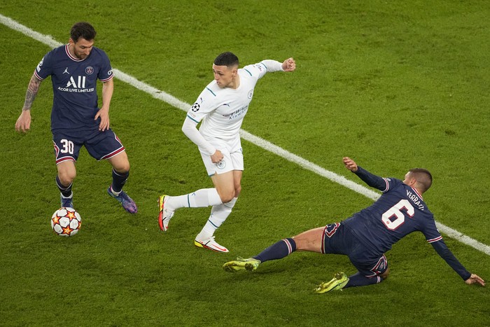 Manchester Citys Phil Foden, centre, battles for the ball with PSGs Lionel Messi, left, and Marco Verratti, right, during the Champions League Group A soccer match between Paris Saint-Germain and Manchester City at the Parc des Princes in Paris, Tuesday, Sept. 28, 2021. (AP Photo/Michel Euler)