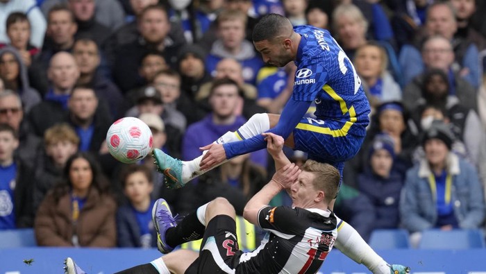 Chelseas Hakim Ziyech, and Newcastles Matt Targett, on the pitch, compete for the ball during the English Premier League soccer match between Chelsea and Newcastle United at Stamford Bridge stadium in London, Sunday, March 13, 2022. (AP Photo/Kirsty Wigglesworth)