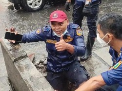 Aksi Petugas Damkar Hujan-hujanan Selamatkan Ponsel di Selokan