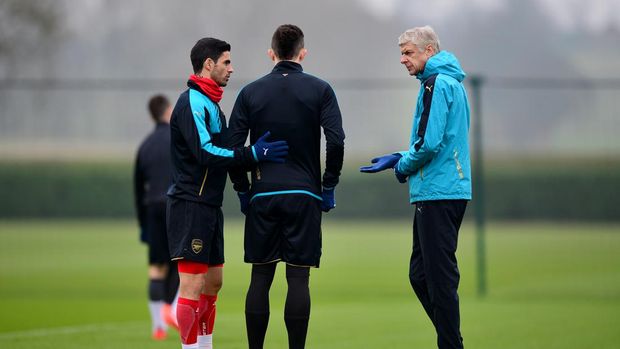 ST ALBANS, ENGLAND - MARCH 15:  Arsene Wenger, Manager of Arsenal speaks with Mikel Arteta and Gabriel Paulista of Arsenal during a training session ahead of the UEFA Champions League round of 16 second leg match between Barcelona and Arsenal at London Colney on March 15, 2016 in St Albans, England.  (Photo by Dan Mullan/Getty Images)