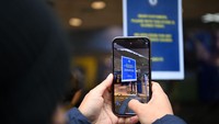 Suporter menjepret pemberitahuan tutupnya toko merchandise Chelsea di Stamford Bridge. Foto: Getty Images/Justin Setterfield