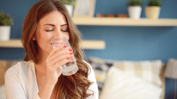 beautiful young woman holding a glass of water