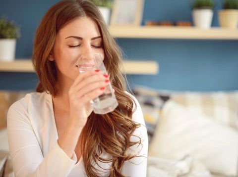 beautiful young woman holding a glass of water