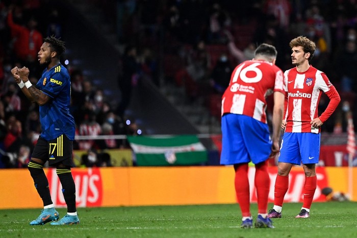 Atletico Madrids French forward Antoine Griezmann (R) reacts as Manchester Uniteds Brazilian midfielder Fred (L) celebrates during the UEFA Champions League football match between Atletico de Madrid and Manchester United at the Wanda Metropolitano stadium in Madrid on February 23, 2022. (Photo by OSCAR DEL POZO / AFP)