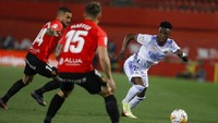 Vinicius Junior dari Real Madrid, kanan, mencoba melewati Dani Rodriguez dari Mallorca, kiri dan Pablo Maffeo.