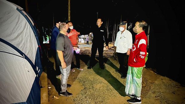 Presiden Joko Widodo bersenda gurau bersama para menteri saat berkemah di Ibu Kota Negara (IKN) Nusantara, Senin (14/3) malam. (Biro Pers Sekretariat Presiden)