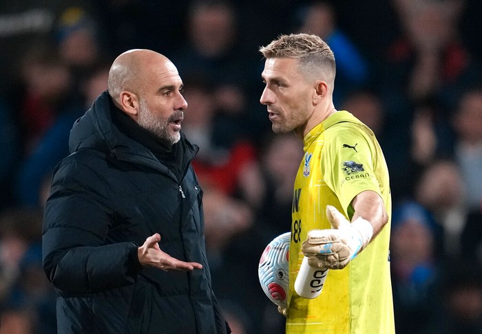 Manchester City's head coach Pep Guardiola, left, speaks. with Crystal Palace's goalkeeper Vicente Guaita at the end of the English Premier League soccer match between Crystal Palace and Manchester City at Selhurst Park stadium in London, Monday, March 14, 2022. (AP Photo/Matt Dunham)