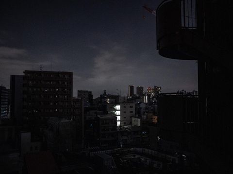 A general view shows residential buildings during a power outage in Koto district in Tokyo on March 16, 2022, after a powerful 7.3-magnitude quake jolted east Japan. (Photo by Philip FONG / AFP)