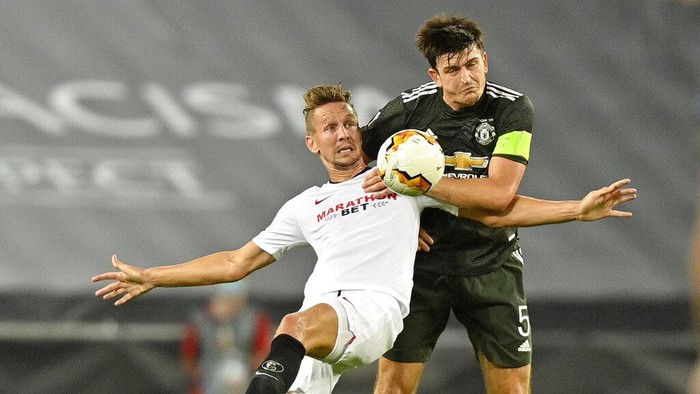 Sevillas Luuk de Jong, left, and Manchester Uniteds Harry Maguire challenge for the ball during an Europa League semifinal match between Sevilla and Manchester United, in Cologne, Germany, Sunday, Aug. 16, 2020. (AP Photo/Martin Meissner, Pool)