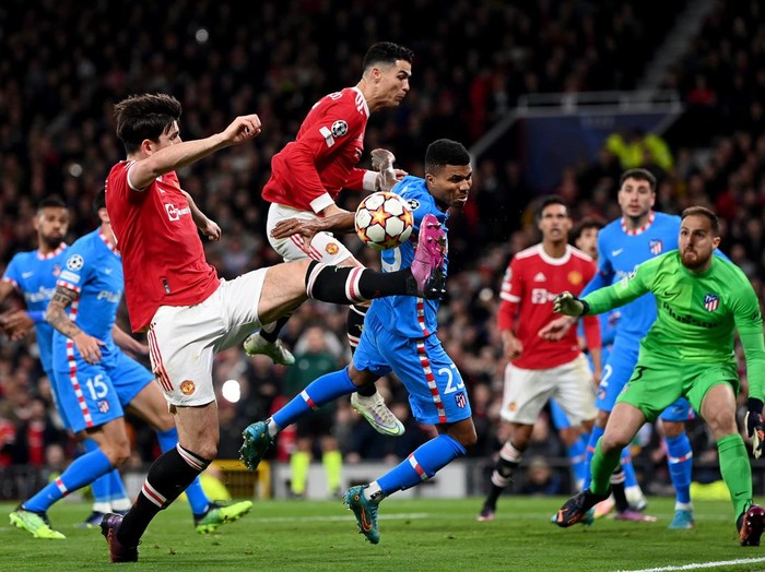 MANCHESTER, ENGLAND - MARCH 15: Cristiano Ronaldo and Harry Maguire of Manchester United stretch for the ball during the UEFA Champions League Round Of Sixteen Leg Two match between Manchester United and Atletico Madrid at Old Trafford on March 15, 2022 in Manchester, England. (Photo by Shaun Botterill/Getty Images)