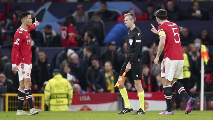 Manchester Uniteds Cristiano Ronaldo, left, and Harry Maguire gesture to a linesman during the Champions League round of 16, second leg soccer match between Manchester United and Atletico Madrid at Old Trafford, Manchester, England, Tuesday, March 15, 2022. (AP Photo/Dave Thompson)