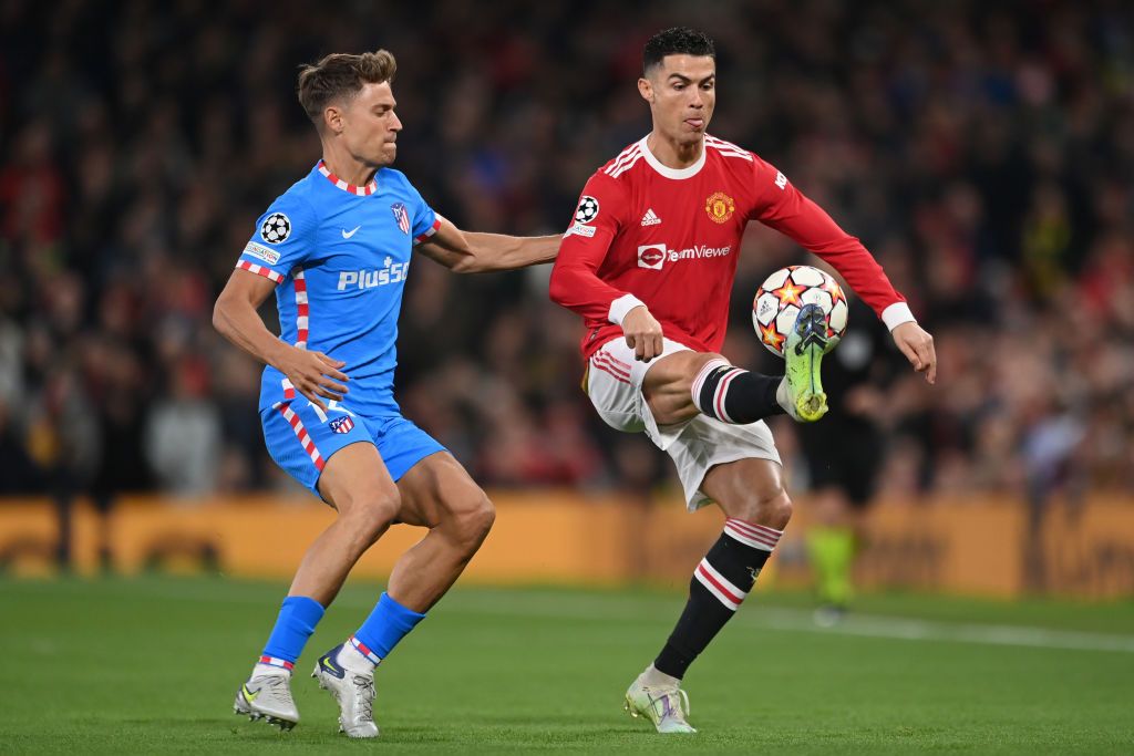MANCHESTER, ENGLAND - MARCH 15: Marcos Llorente of Atletico Madrid challenges Cristiano Ronaldo of Manchester United during the UEFA Champions League Round Of Sixteen Leg Two match between Manchester United and Atletico Madrid at Old Trafford on March 15, 2022 in Manchester, England. (Photo by Michael Regan/Getty Images)