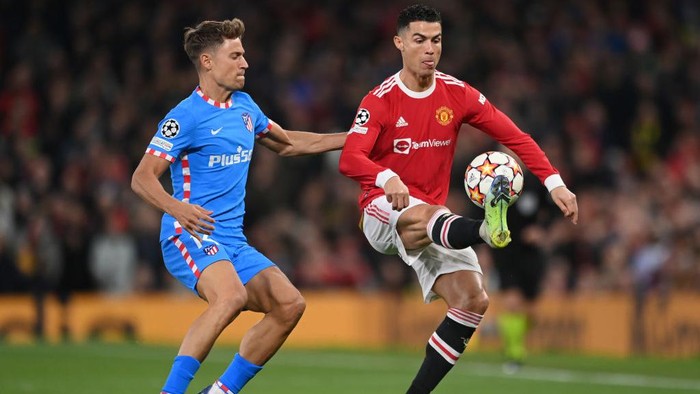 MANCHESTER, ENGLAND - MARCH 15: Marcos Llorente of Atletico Madrid challenges Cristiano Ronaldo of Manchester United during the UEFA Champions League Round Of Sixteen Leg Two match between Manchester United and Atletico Madrid at Old Trafford on March 15, 2022 in Manchester, England. (Photo by Michael Regan/Getty Images)