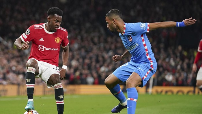 Manchester Uniteds Anthony Elanga, left, and Atletico Madrids Renan Lodi, right, battle for the ball during the Champions League round of 16, second leg soccer match between Manchester United and Atletico Madrid at Old Trafford, Manchester, England, Tuesday, March 15, 2022. (AP Photo/Dave Thompson)