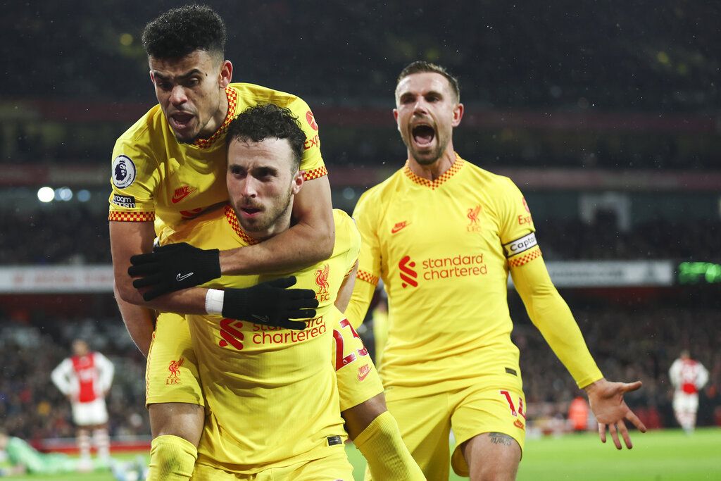 Liverpool's Roberto Firmino, right, embraces teammate Andrew Robertson following the English Premier League soccer match between Arsenal and Liverpool at Emirates Stadium in London, Wednesday, March 16, 2022. (AP Photo/Ian Walton)