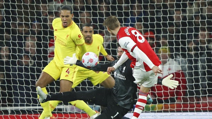 Liverpool's Roberto Firmino, right, embraces teammate Andrew Robertson following the English Premier League soccer match between Arsenal and Liverpool at Emirates Stadium in London, Wednesday, March 16, 2022. (AP Photo/Ian Walton)