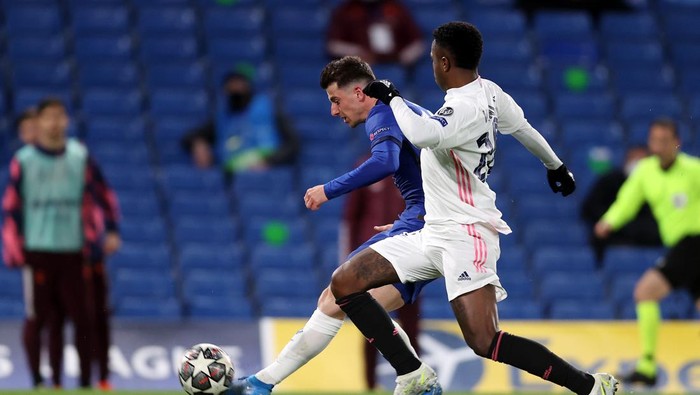 LONDON, ENGLAND - MAY 05: Mason Mount of Chelsea shoots under pressure from Vinicius Junior of Real Madrid during the UEFA Champions League Semi Final Second Leg match between Chelsea and Real Madrid at Stamford Bridge on May 05, 2021 in London, England. Sporting stadiums around Europe remain under strict restrictions due to the Coronavirus Pandemic as Government social distancing laws prohibit fans inside venues resulting in games being played behind closed doors. (Photo by Clive Rose/Getty Images)